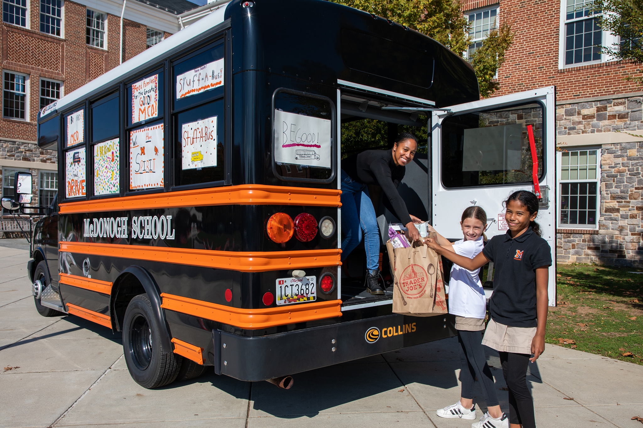 5th-grade students in the Greatest Good McDonogh program hand Program Manager Artie Spruill donations for the Maryland Food Bank during the annual Stuff-A-Bus initiative.